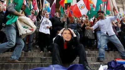 A peace activist wears a mask depicting Anders Fogh Rasmussen, the Nato secretary general, in a Brussels protest yesterday.
