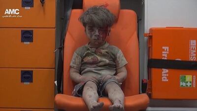 Omran Daqneesh, 5, sits inside an ambulance after being rescued from the rubble un the aftermath of an air raid on Aleppo. Aleppo Media Center via AP