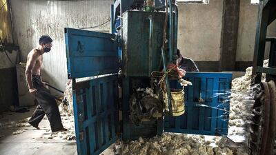 A worker gathers up imported sheep’s wool after it was processed and bleached at a factory near Zhangzhou. China is the major market for Australian wool, with more than 75 per cent of Ausralia's wool clip output exported to China for processing. Kevin Frayer / Getty Images