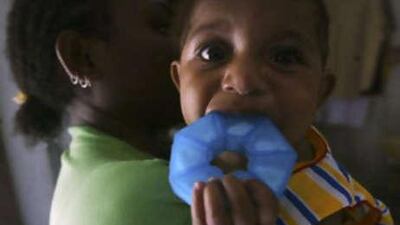 A HIV-infected mother holds her 10 month-old-baby girl, who is free from the affliction, in a shelter house in Jayapura, Indonesia.