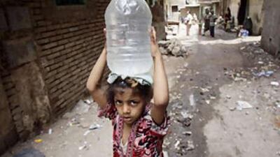 A girl carries a container filled with water from the Nile from a pump in Manshiyet Nasser shanty town in eastern Cairo.