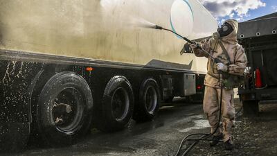 A Revolutionary Guard member disinfects a truck in the city of Sanandaj, western Iran, March 1. Tasnim News Agency via AP