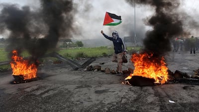 A protester in the West Bank waves a Palestinian flag. EPA