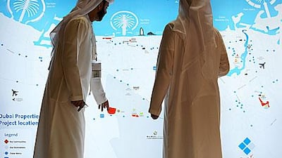 Visitors study a map at the Dubai Properties Group stand on the first day of Cityscape.