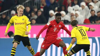 Bayern midfielder Alphonso Davies takes on Dortmund midfielder Mario Gotze. Getty Images