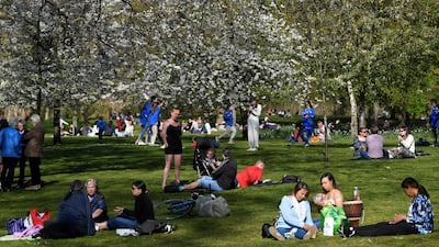 People relax in the sunshine, as lockdown restrictions are eased, in St. James's Park, London. Reuters