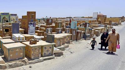 Shiite family visit the graves of their relatives at Wadi al-Salam cemetery during Eid Al Fitr in the Iraqi city of Najaf. AFP