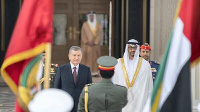 Sheikh Mohamed bin Zayed and Mr Mirziyoyev stand for the national anthem during a reception at the Presidential Palace.