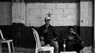 Men wait at a checkpoint in Homs in 2012. Courtesy Phil Sands