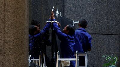 Workers cover a window to block the view inside a building at the Indonesia Stock Exchange. Darren Whiteside / Reuters