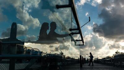 A couple take photos at sunset on the Tsim Sha Tsui promenade in Hong Kong, China. Jermove Favre / EPA