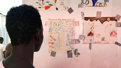 A rescued migrant called Dame Diop looks at the baobab he drew.