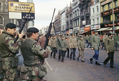 In this August 1972 file photo, British troops watch as members of the Ulster Defence Association parade through Belfast, Northern Ireland. AP