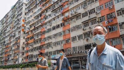 Pedestrians cross a road past apartment blocks in Hong Kong’s To Kwa Wan area. AFP