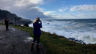 Onlookers use smartphones to film waves crashing ashore at Rodea Point in Lincoln County, Oregon during an extreme high tide that coincided with a big winter storm. AP Photo/Gillian Flaccus