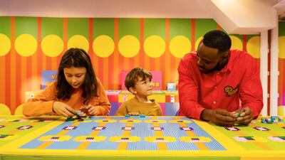 Designer Yinka Ilori speaks with children inside his art installation