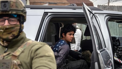 A handcuffed man sits inside a vehicle during a raid by US Customs and Border Protection agents in Kenner, Louisiana. AFP