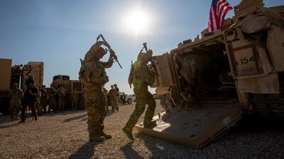 Soldiers enter armoured vehicles at a US military base at an undisclosed location in Northeastern Syria on Monday. AP