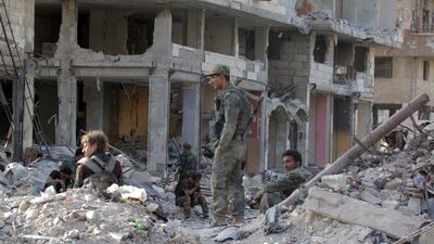 Syrian soldiers sit in the rubble in the Al Hajar Al Aswad neighbourhood in south Damascus, Syria, on May 21, 2018. Youssef Badawi / EPA