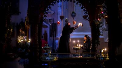 A Lithuanian Orthodox Church believers light candles before the Orthodox Christmas celebration Mass in the empty Orthodox Church of the Holy Spirit in Vilnius, Lithuania. AP Photo