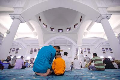 A father and son together for Eid prayers. Victor Besa / The National