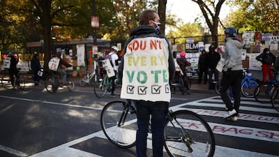 A cyclist wears a banner at Black Lives Matter plaza near the White House after Election Day in Washington, U.S., November 5, 2020. REUTERS/Hannah McKay