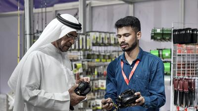 An enthusiast looks at a fishing reel for sale.