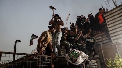 Protesters climb a fence as they gather near the Swedish embassy in Baghdad hours after it was stormed and set on fire ahead of an expected Quran burning in Stockholm. Reuters