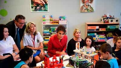 US first lady Melania Trump, centre, speaks with people during a visit to the Necker Hospital in Paris, on July 13, 2017. The US president arrived in Paris for a presidential visit filled with Bastille Day pomp and which the White House hopes will offer respite from rolling scandal backing home. Martin Bureau / AFP