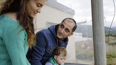 Lebanese soldier George Al Khoury, who was kidnapped by militant groups in August 2014 in the eastern border town of Arsal, stands with his wife and one of their two sons at their house on December 2. AFP Photo