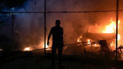 A Palestinian looks on as the tented area in the courtyard of Al Aqsa Hospital in Deir Al Balah burns. AP