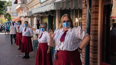 Restaurant workers greet returning guests on Main Street USA during the reopening of the Disneyland theme park in Anaheim, California, US, on Friday, April 30, 2021. Bloomberg