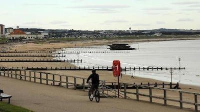 A cyclist rides past the beach in Aberdeen, Scotland. Russell Cheyne / Reuters