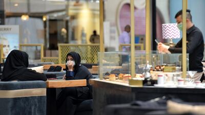 Saudi women sit at a cafe in a shopping mall in the Saudi capital Riyadh after it reopened following the easing of some restrictions put in place by the authorities in a bid to stem the spread of the novel coronavirus. AFP