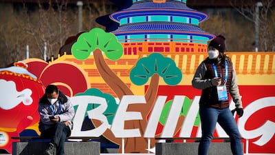 A woman walks past an Olympic-themed decoration on the Olympic Green at the 2022 Winter Olympics. AP