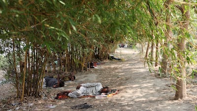 Men sleep in the shade on the banks of the Yamuna River. Reuters