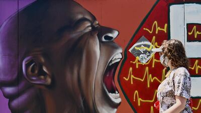 A person walks past a street mural by artist Vincent Ballentine in the Brooklyn Borough of New York City. AFP