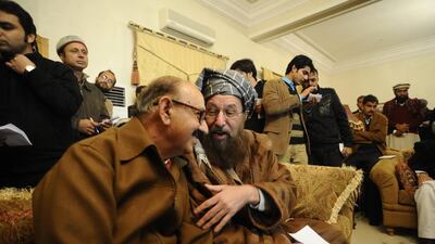 Taliban representative Maulana Samiul Haq, right, and Special Assistant to Pakistan’s Prime Minister, Irfan Siddiqui (L) talk after their meeting at the Khyber Pakhtunkhwa House in Islamabad on Thursday. EPA