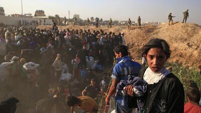 Syrian refugees try to cross into Turkey from Syria, in Akcakale, southeastern Turkey. AP