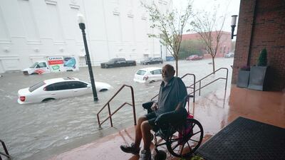 A man watches flood waters in downtown Pensacola, Florida. AP Photo