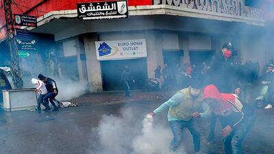 A protester returns a tear gas canister during clashes with security forces near the Serail in the northern port city of Tripoli. AFP