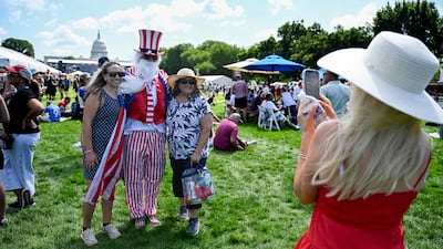 Fans pose for photos with a man dressed as Uncle Sam. AFP