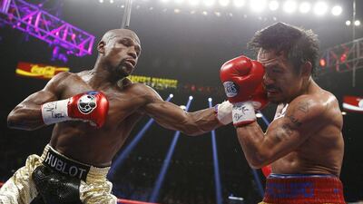 Floyd Mayweather punches Manny Pacquiao during their title bout on Sunday morning in Las Vegas. John Locher / AP / May 3, 2015
