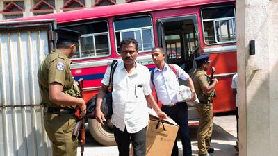 Policemen stand guard as electoral officials bring election materials to a polling station in Colombo. AFP