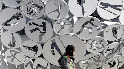 A workman passes discs of Olympic sports decorating a large Olympic sports structure at the Alpensia resort before the start of the Pyeongchang 2018 Olympic Games. Barbara Walton / EPA