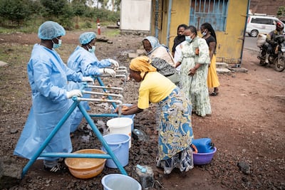 People wash their hands at a checkpoint set up for preventive measures against the spread of Ebola in the village of Kanyaruchinya, in DR Congo. Photo: EPA