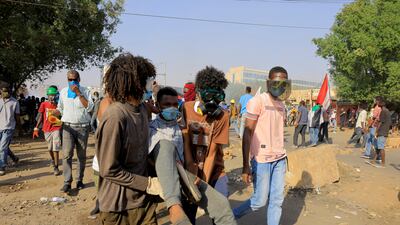 Sudanese anti-military protesters carry an injured demonstrator in Khartoum. Photo: Reuters.