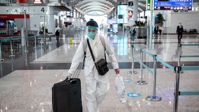 A passenger wearing protective equipment wheels his luggage to a check-in counter at Istanbul Airport in Turkey. Getty Images
