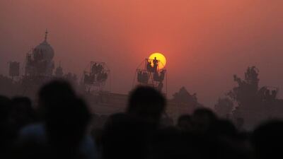 People ride on swings at a fairground as the sun sets in the background on the ocassion of Dussehra festival in Faridabad, a suburb of New Delhi, India. Money Sharma / EPA