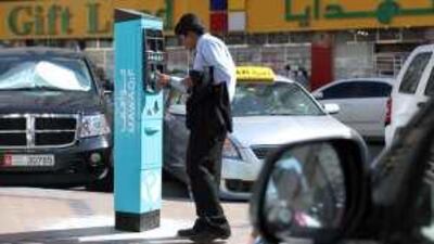 A motorist works out how to use a new parking ticket dispenser on Hamdan Street, Abu Dhabi yesterday.